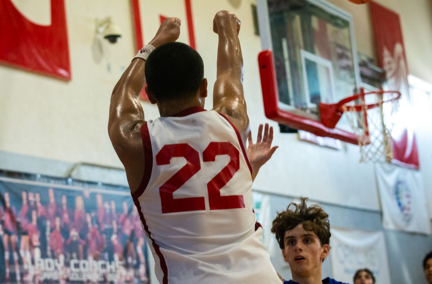 Basketball players compete for position during an intense game in a gymnasium.