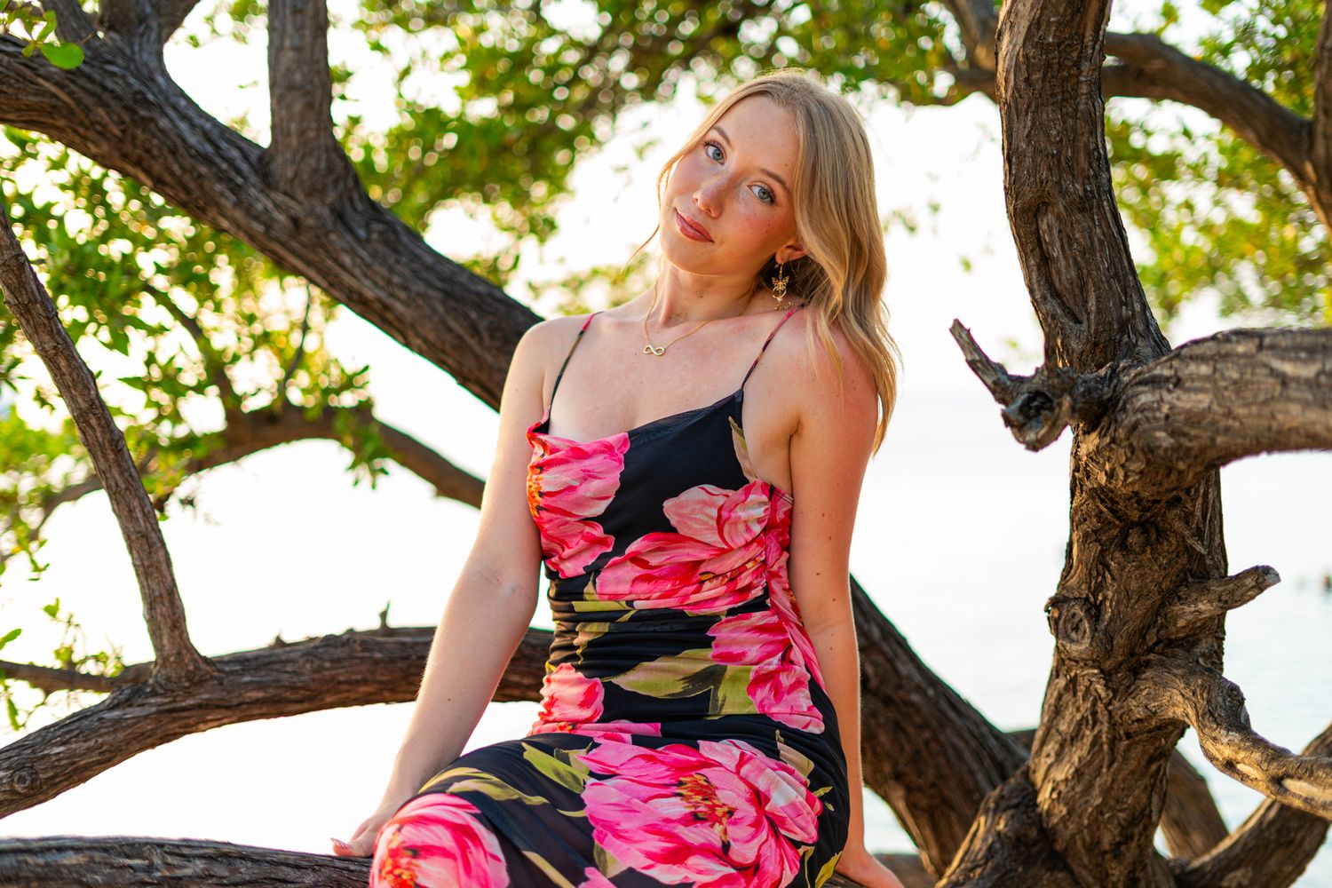 A floral dress photoshoot in front of a branching tree.