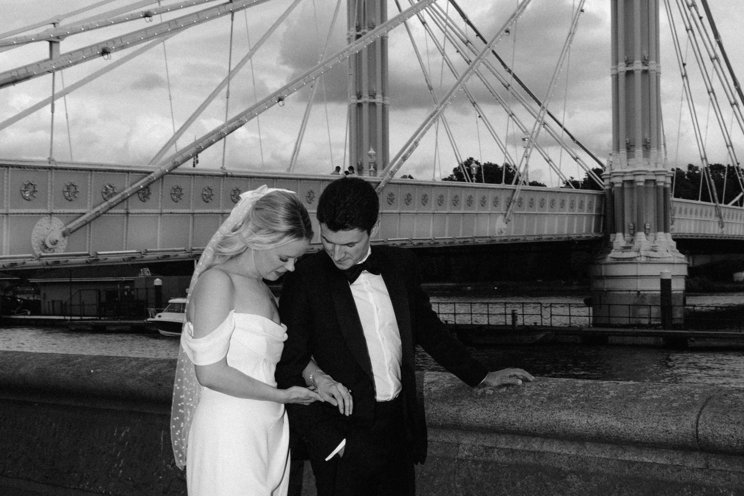 Black and white photo series showing a couple in formal attire posing on a bridge for their romantic wedding shoot.