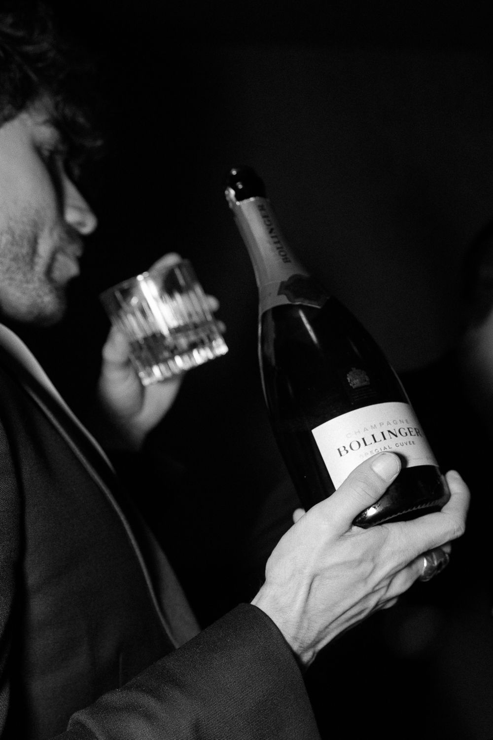 Dark moody black and white photographs show hands holding various bottles in a sequence.