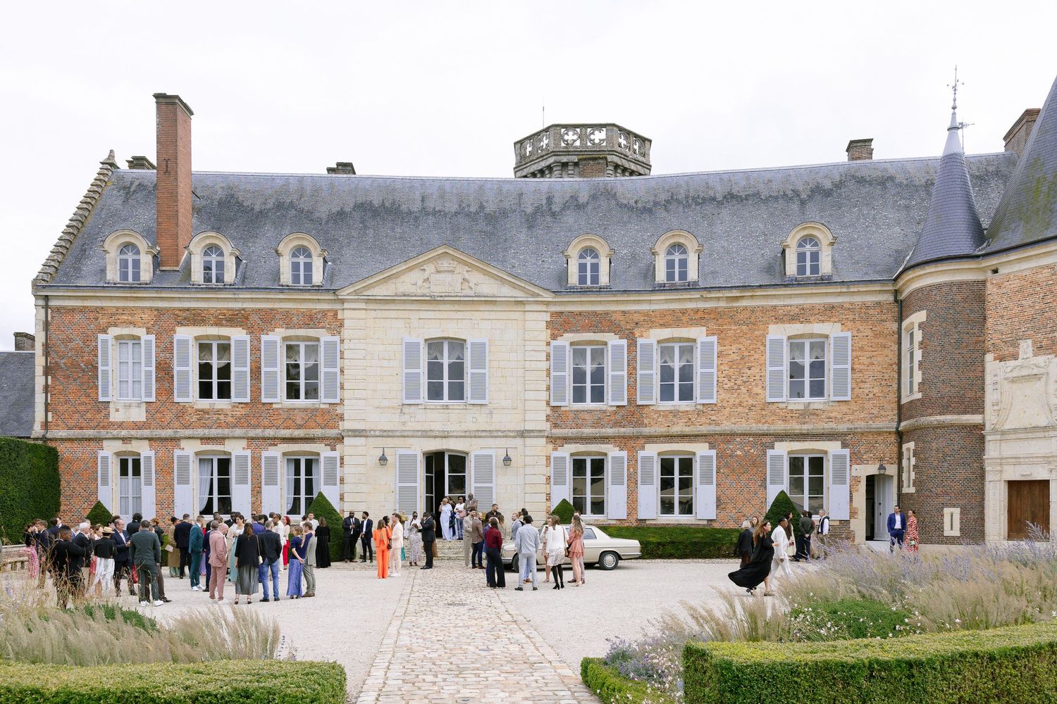 A grand French chateau wedding venue with elegant architecture and manicured grounds hosts a formal celebration.