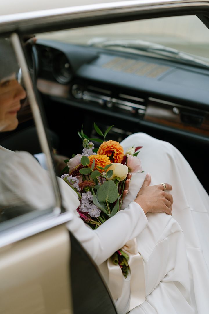 A series of close-up shots showing hands holding a colorful floral bouquet against a white dress and car interior.