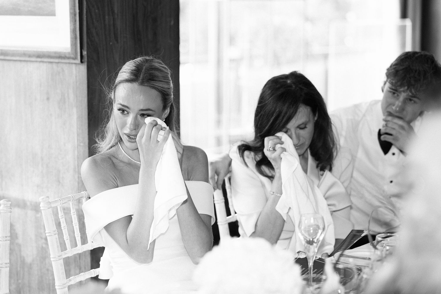 A grid of black and white wedding day photos showing emotional moments during a celebration.