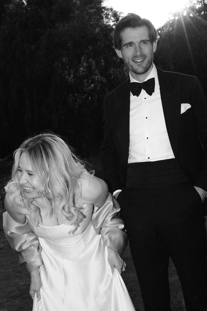 A romantic black and white photo series of a couple in formal wedding attire dancing and embracing outdoors at sunset.