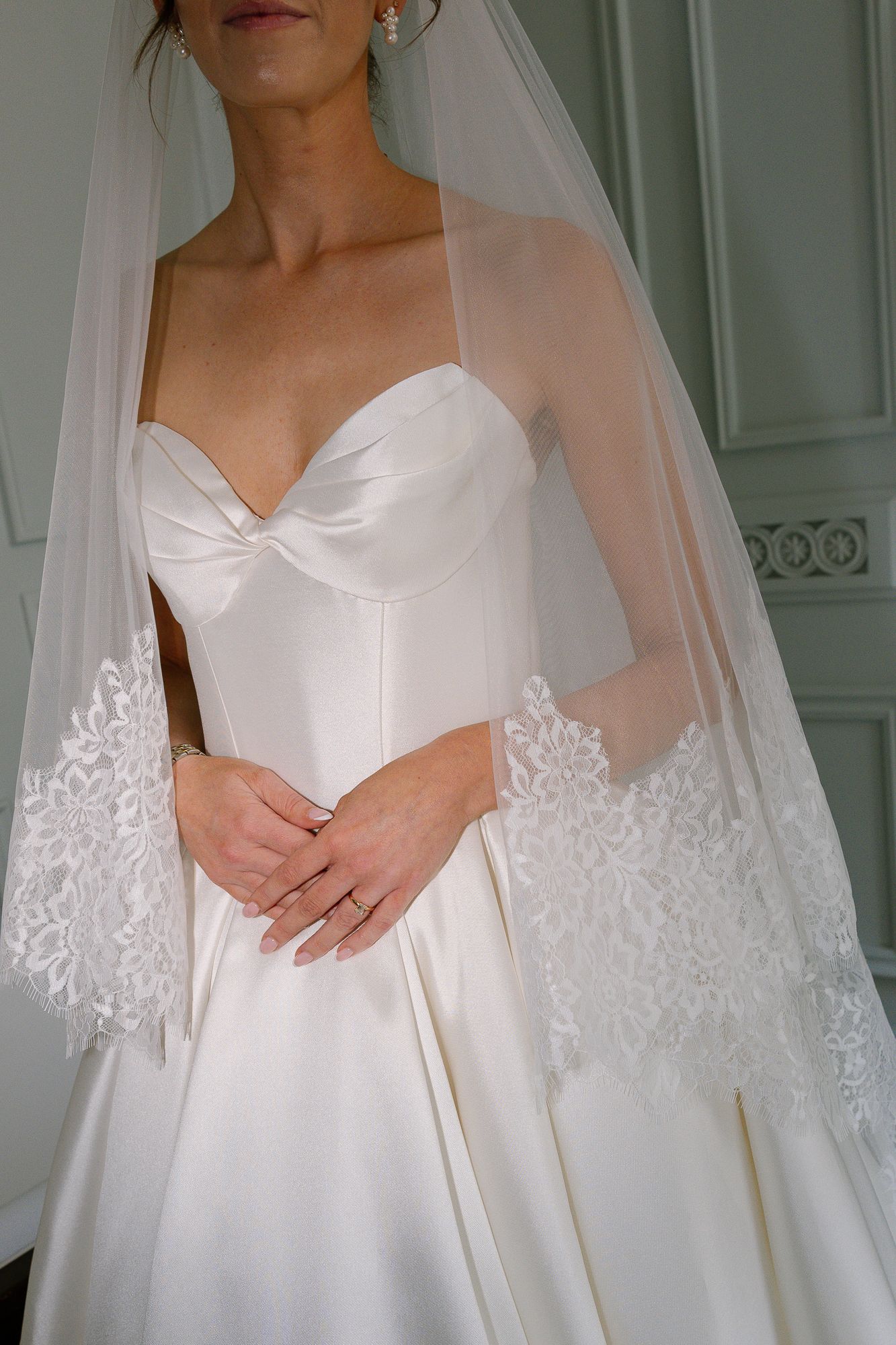 Four close-up views of a bride wearing an elegant white wedding dress with delicate lace-trimmed veil details.