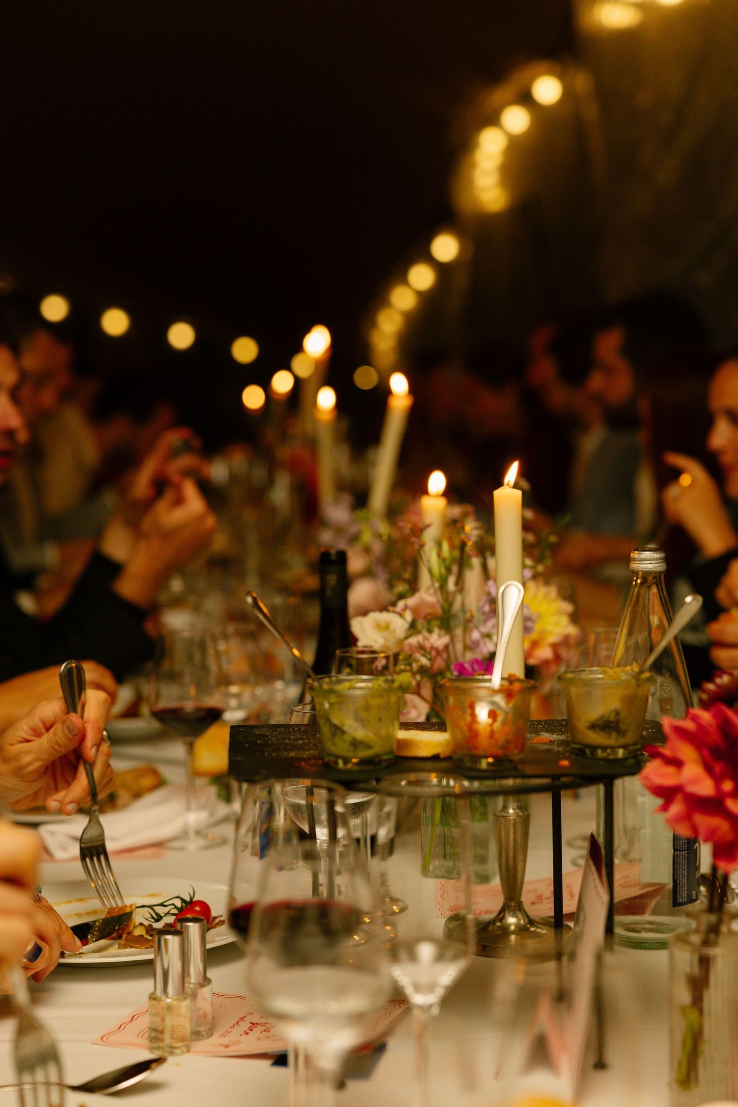 Candlelit wedding reception table with rustic decor, mason jars, and romantic lighting creating an intimate atmosphere.