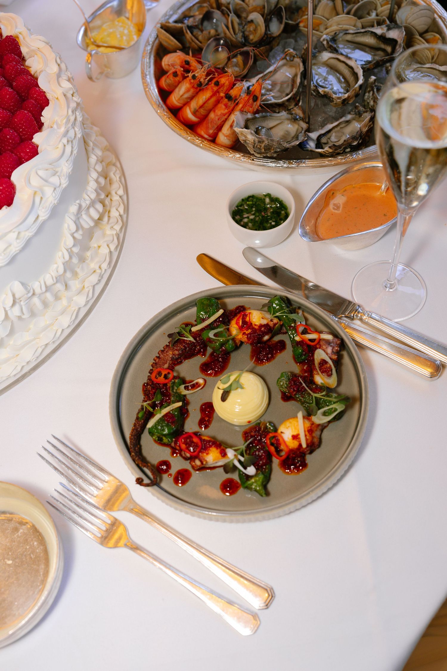 Elegant wedding reception table with seafood, salads and fine dining place settings.