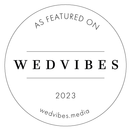 Circular white and black Wedvibes 2023 featured vendor badge logo.