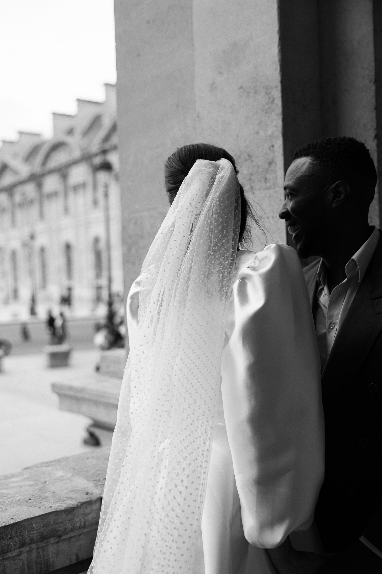 Black and white photograph showing traditional white veil with delicate lace patterns in a wedding setting.