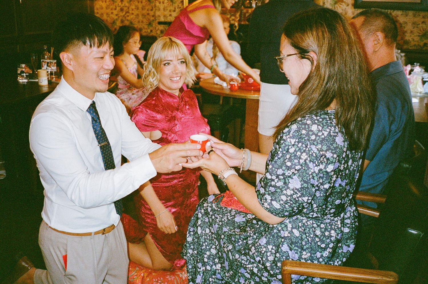 Vintage film photos show people gathered at a social event enjoying drinks and conversation in warm lighting.