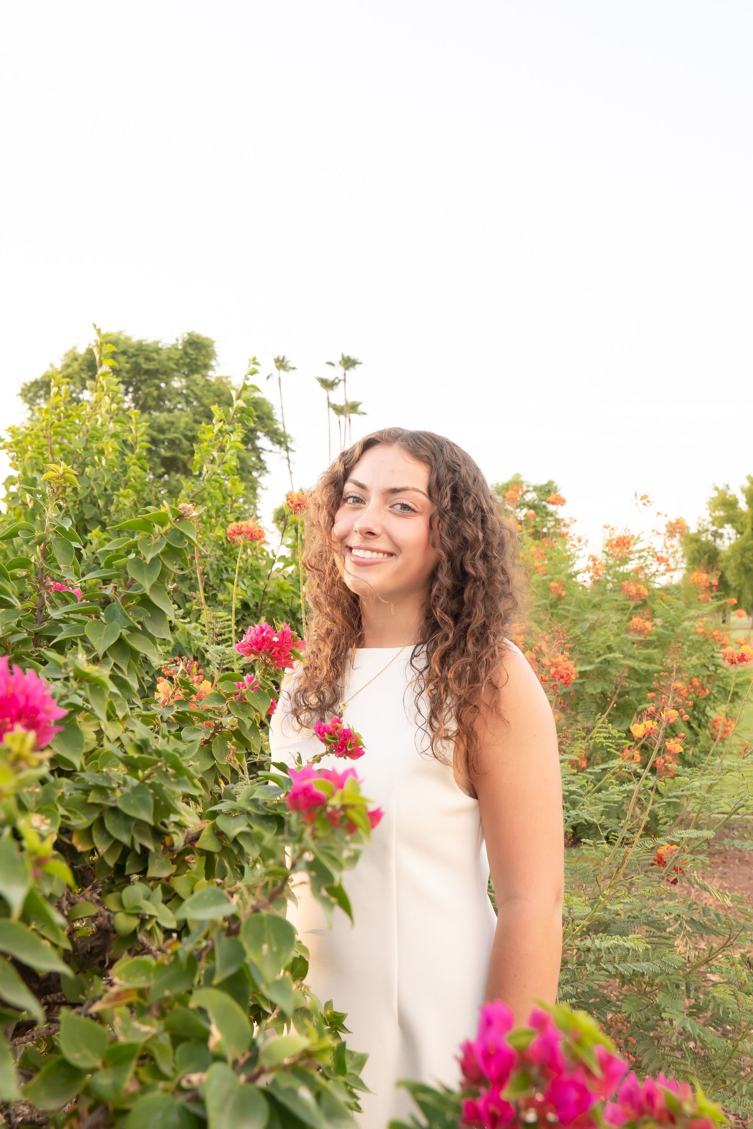 Senior photos outdoors in Arizona desert and beautiful flowers with natural poses
