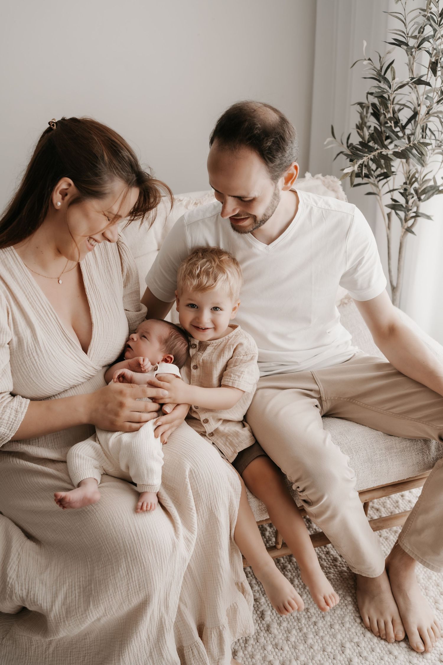 Lifestyle family session showing intimate moments between parents and children on white bedding.