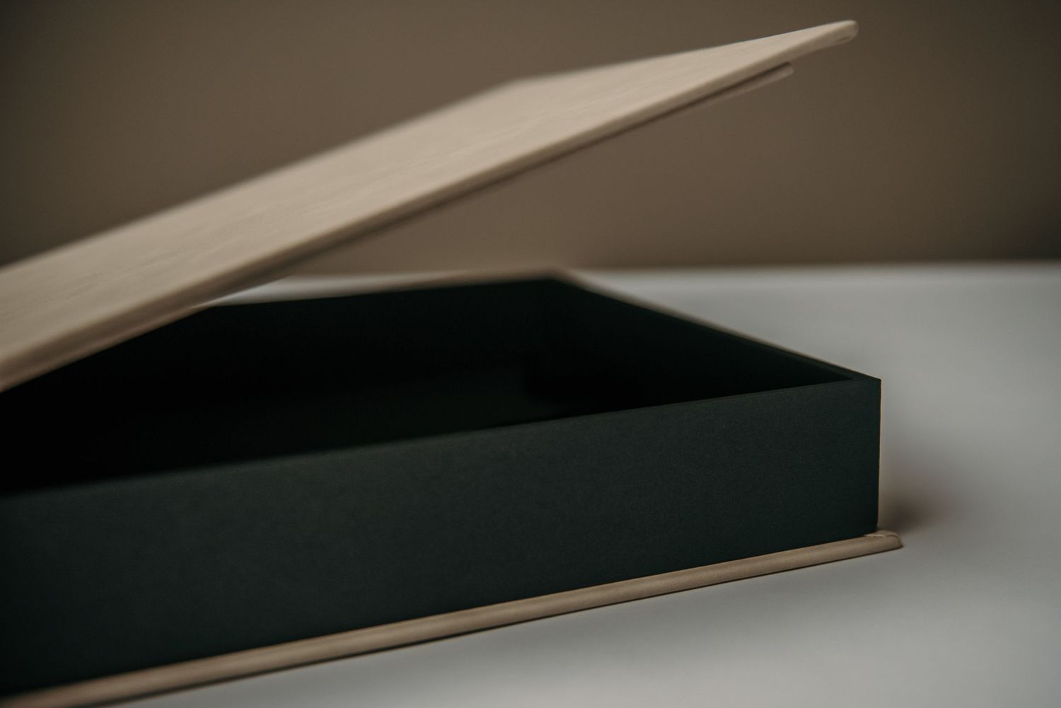 Professional black photo albums arranged in a row on a wooden surface.