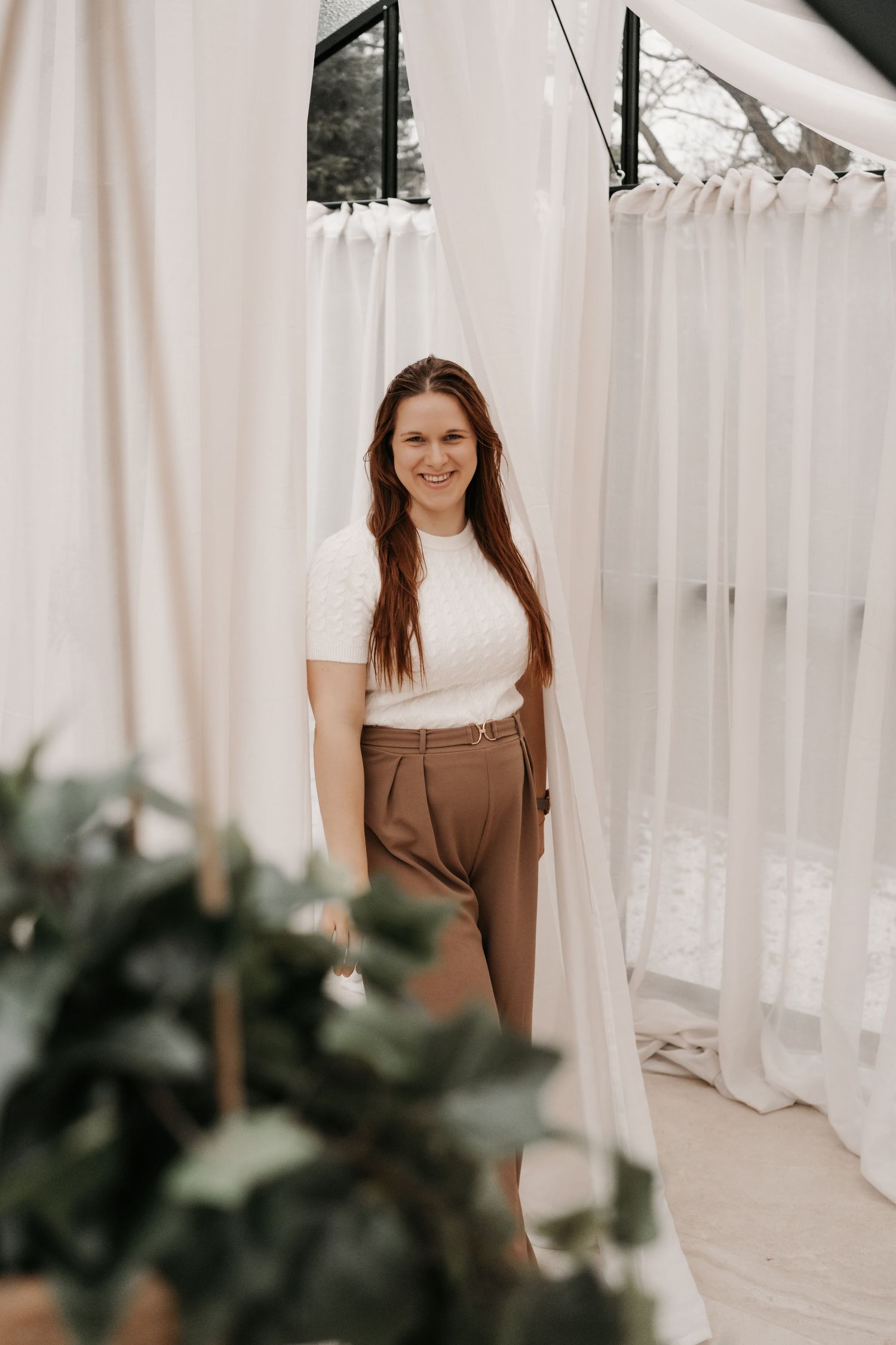 Portrait session in bright studio with white curtains and natural lighting.