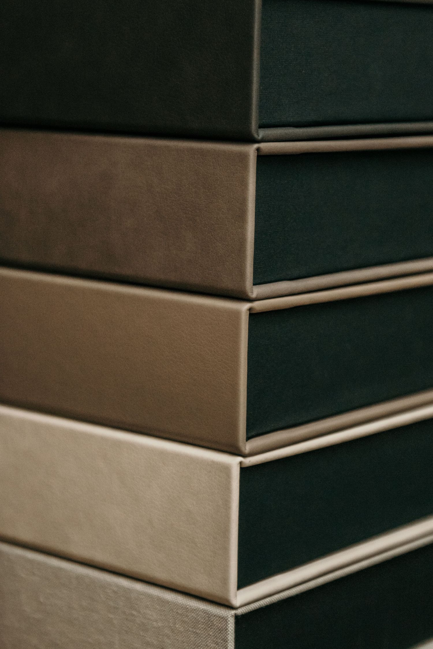 Stack of premium photo albums with varying neutral-toned covers.