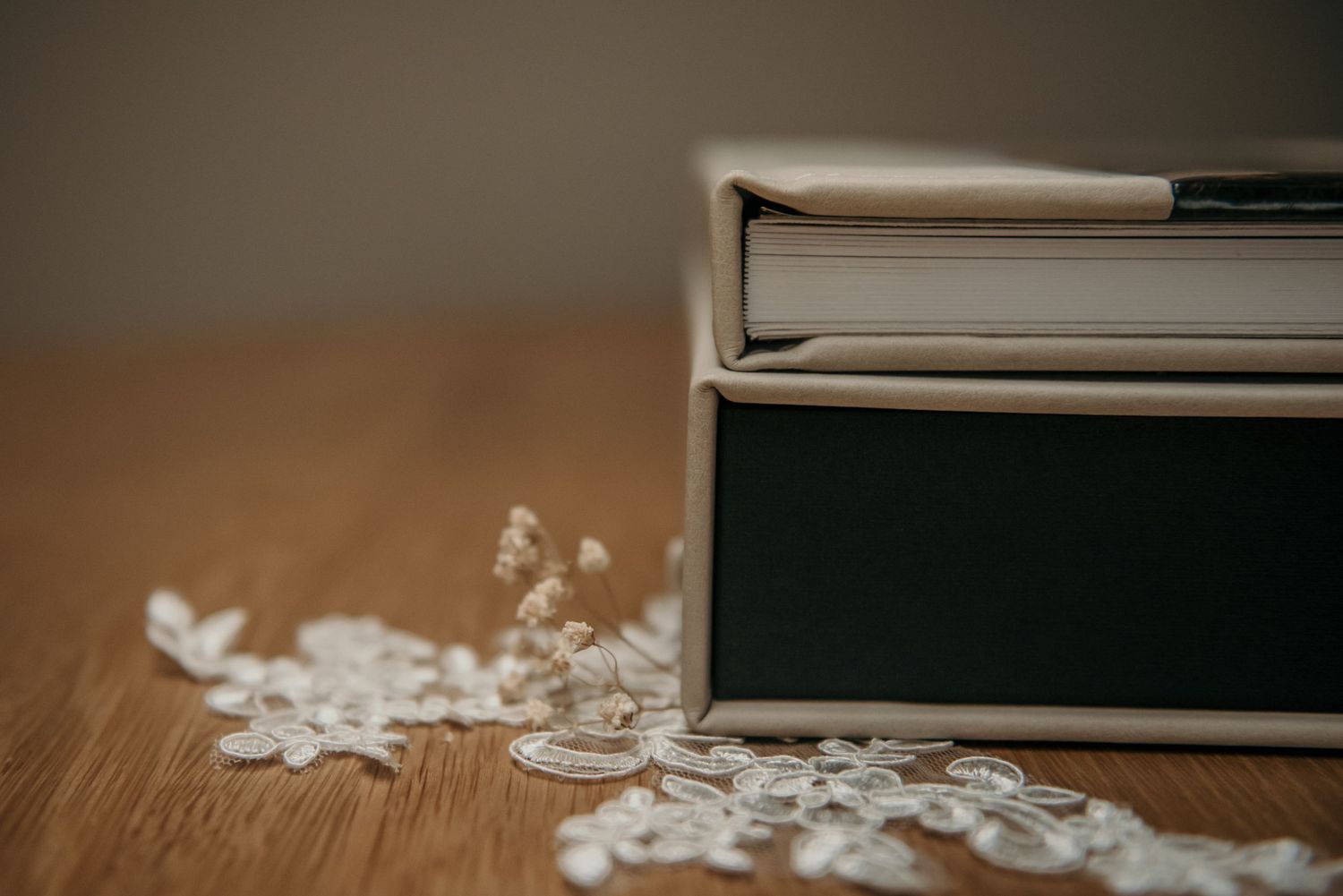 Black leather photo albums arranged on wooden surface with soft lighting.