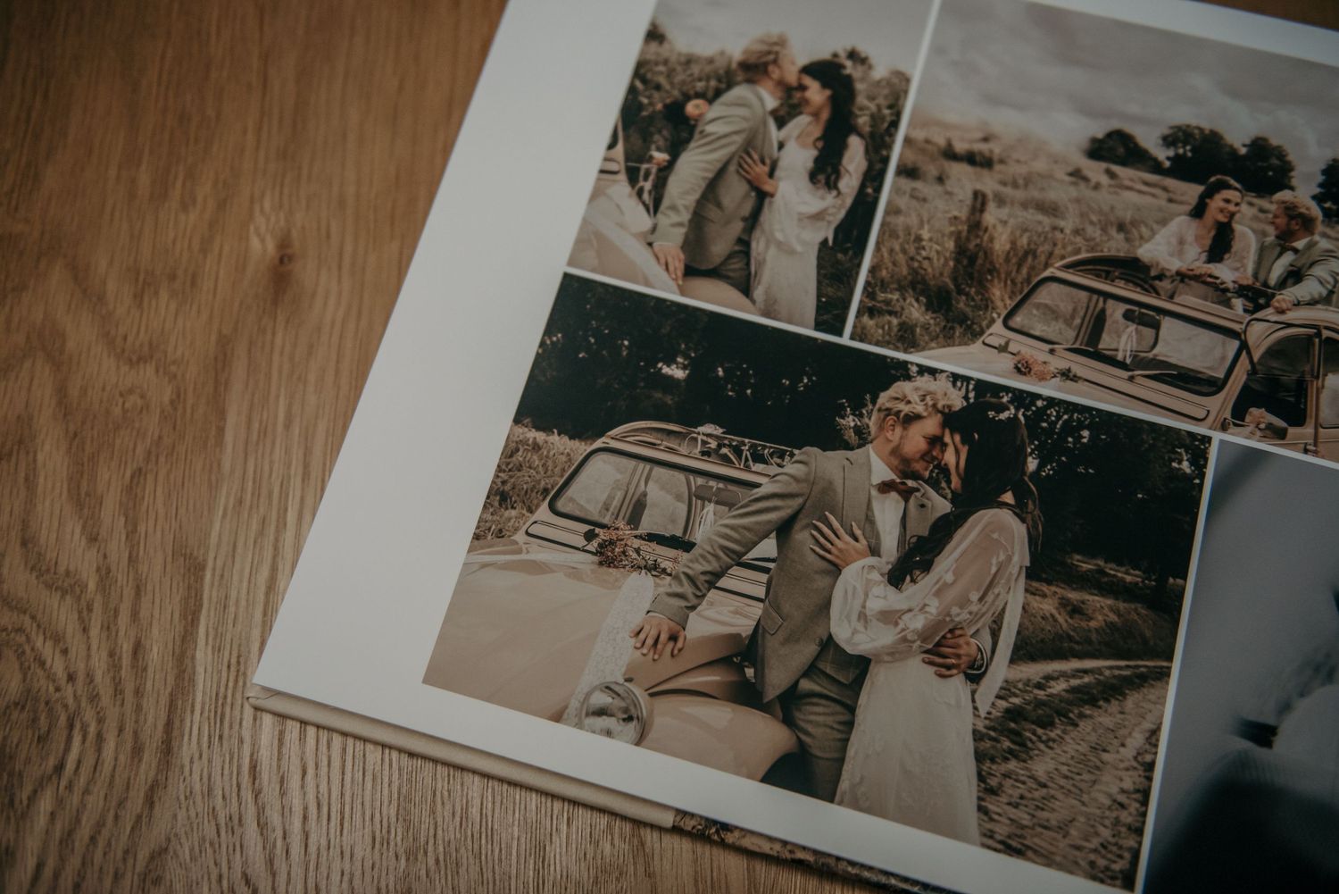 Open wedding album showing professional photography layouts on wooden table.