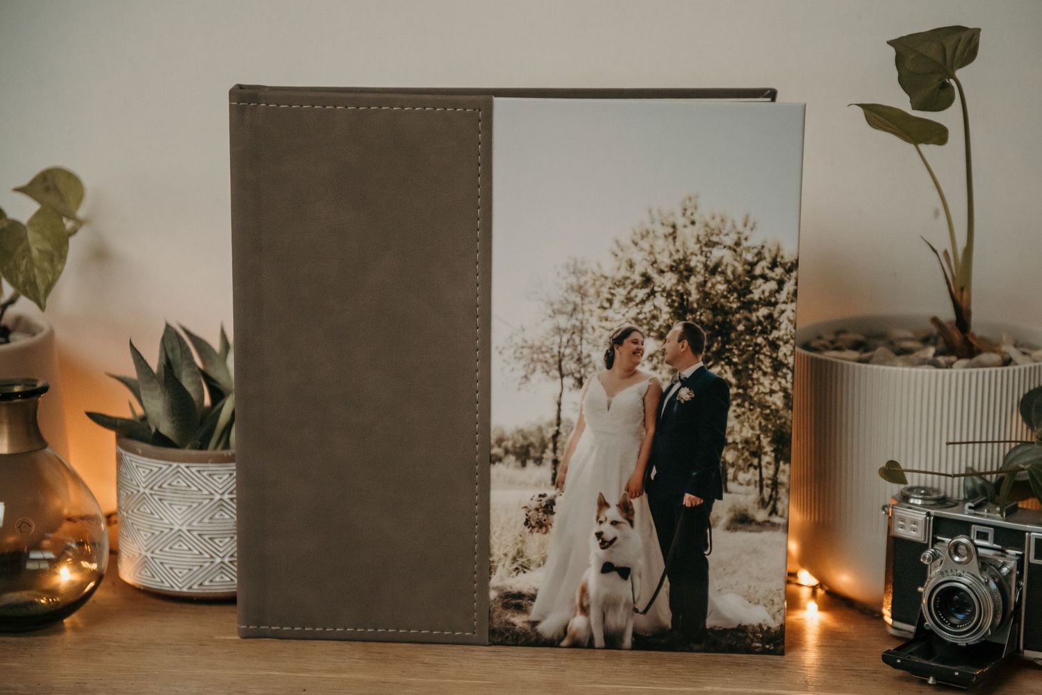 Decorative display of photo albums with vintage cameras and candles on a wooden surface.