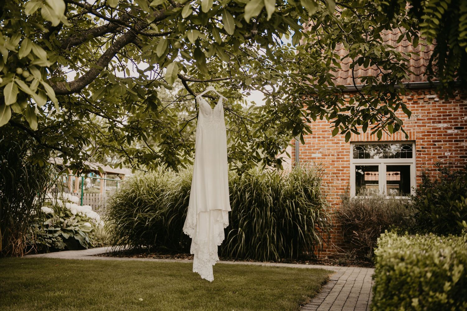 Elegant wedding venue exterior with brick walls and garden landscaping.
