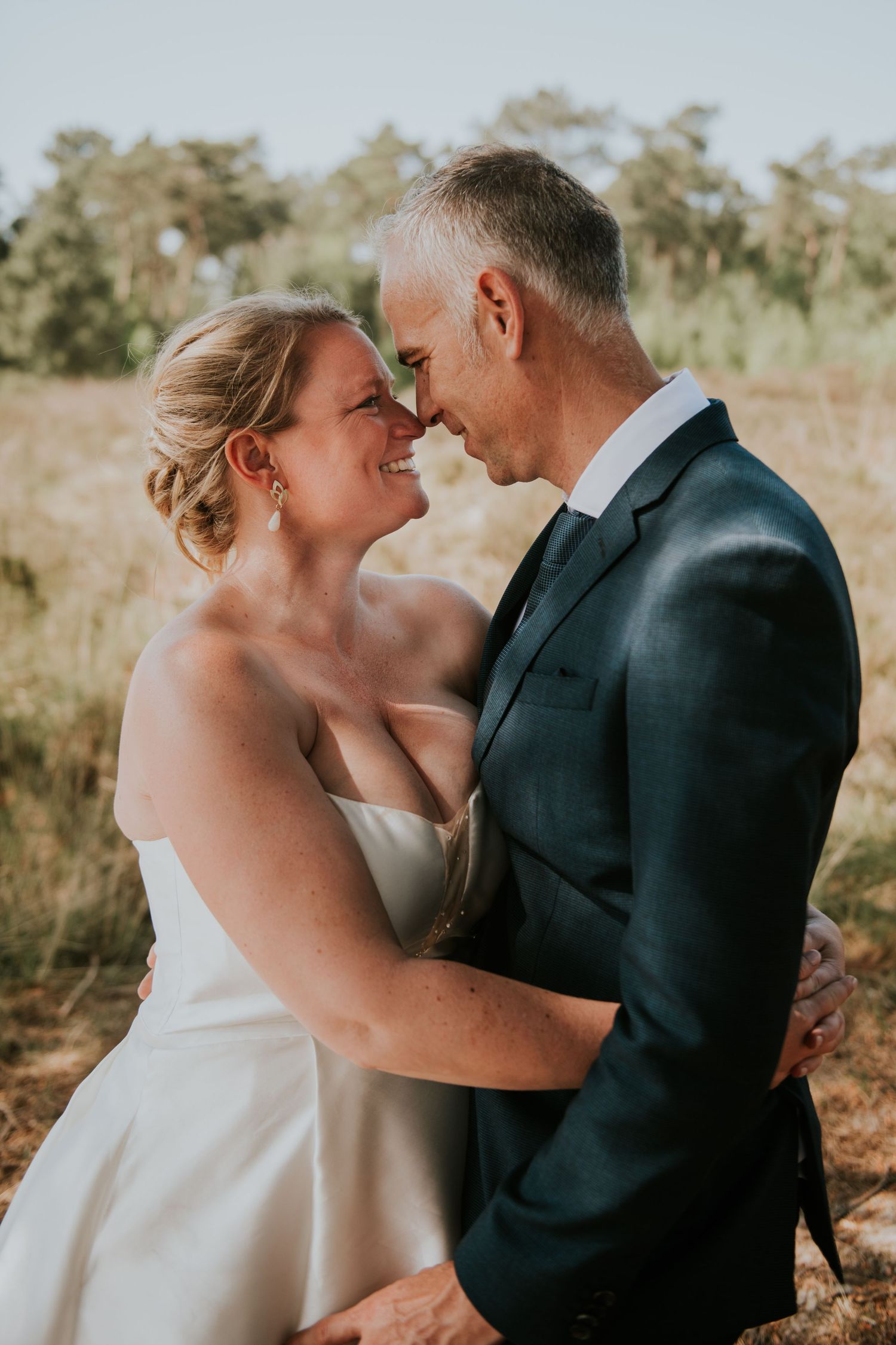Intimate wedding portraits captured in golden sunlight against a natural backdrop.