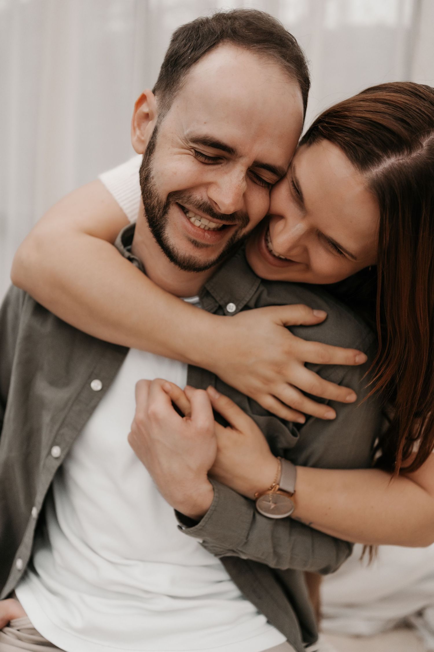Intimate couple portrait session showing joyful embraces and laughter.