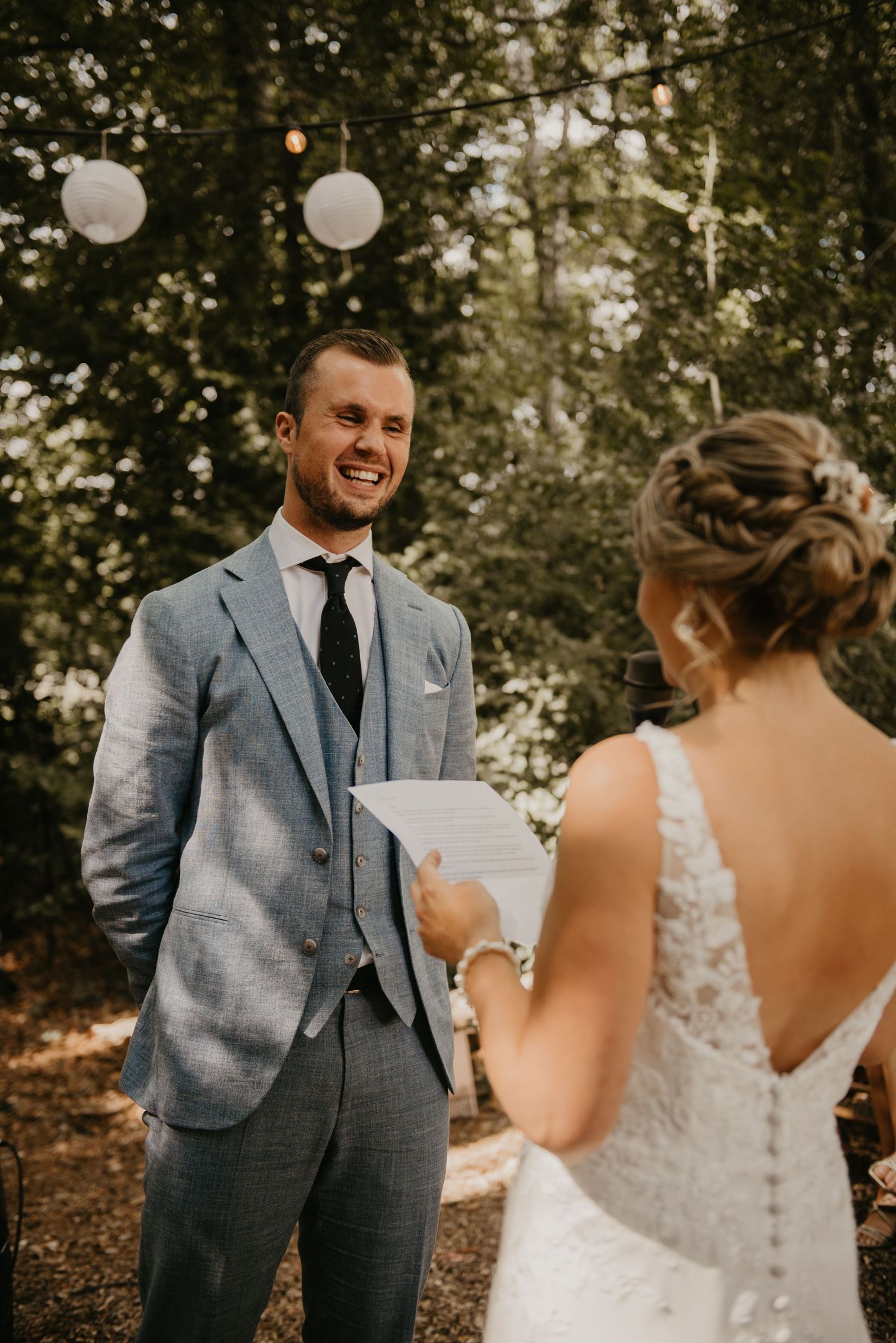 A couple shares their first look moment in a wooded outdoor setting during their wedding.