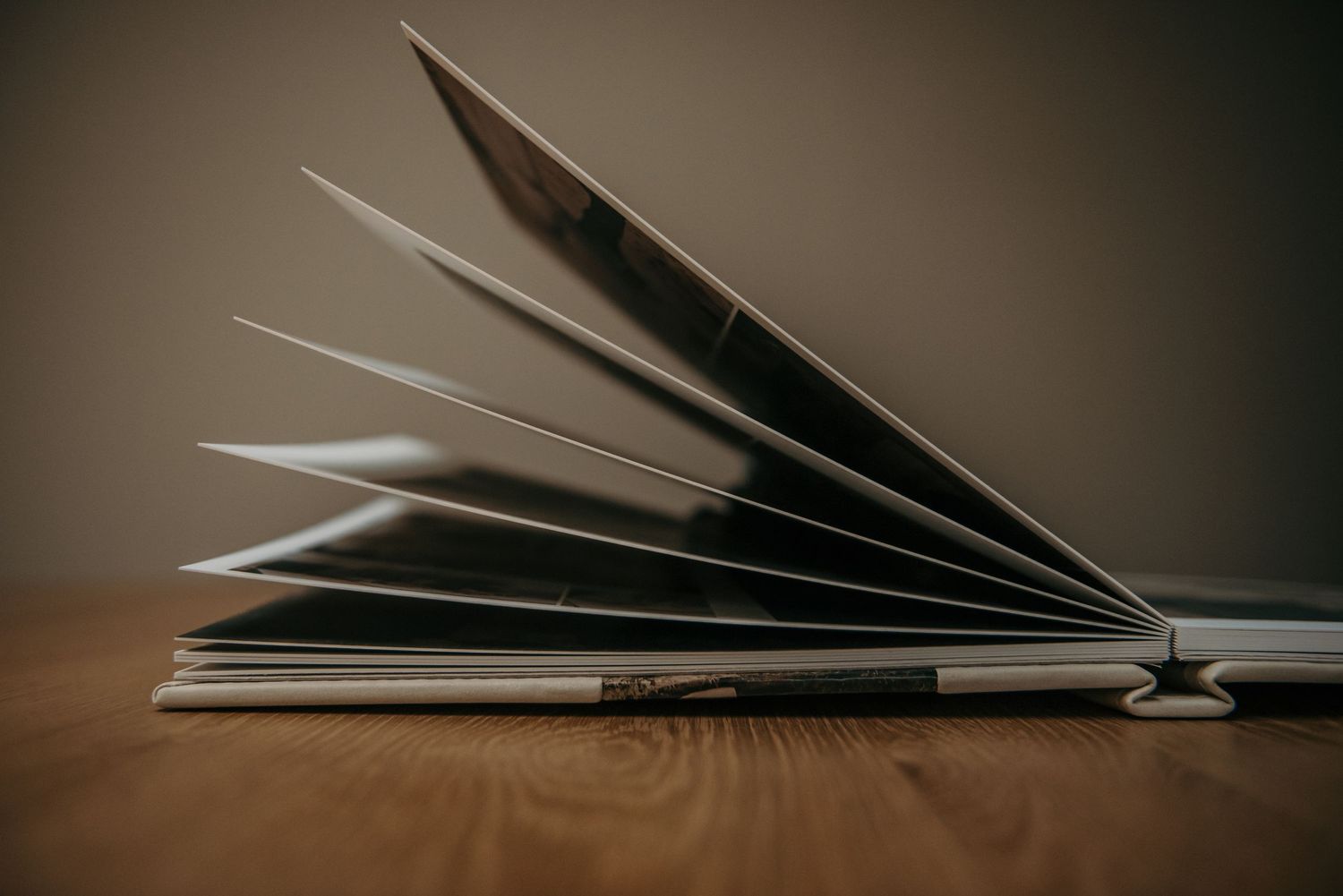Open photo album with pages fanned out creating artistic shadows.