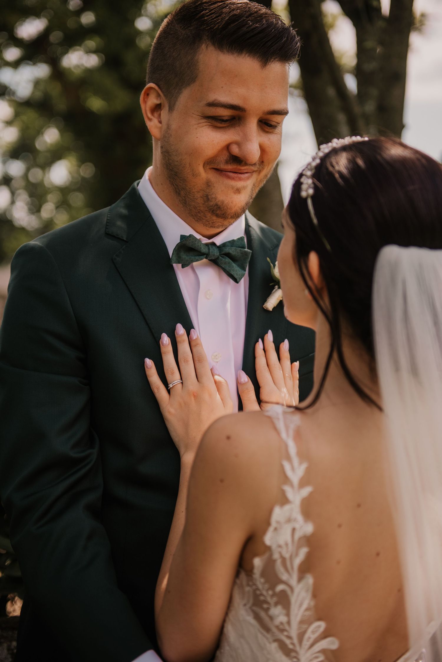 Close-up of newlyweds sharing tender moment outdoors.