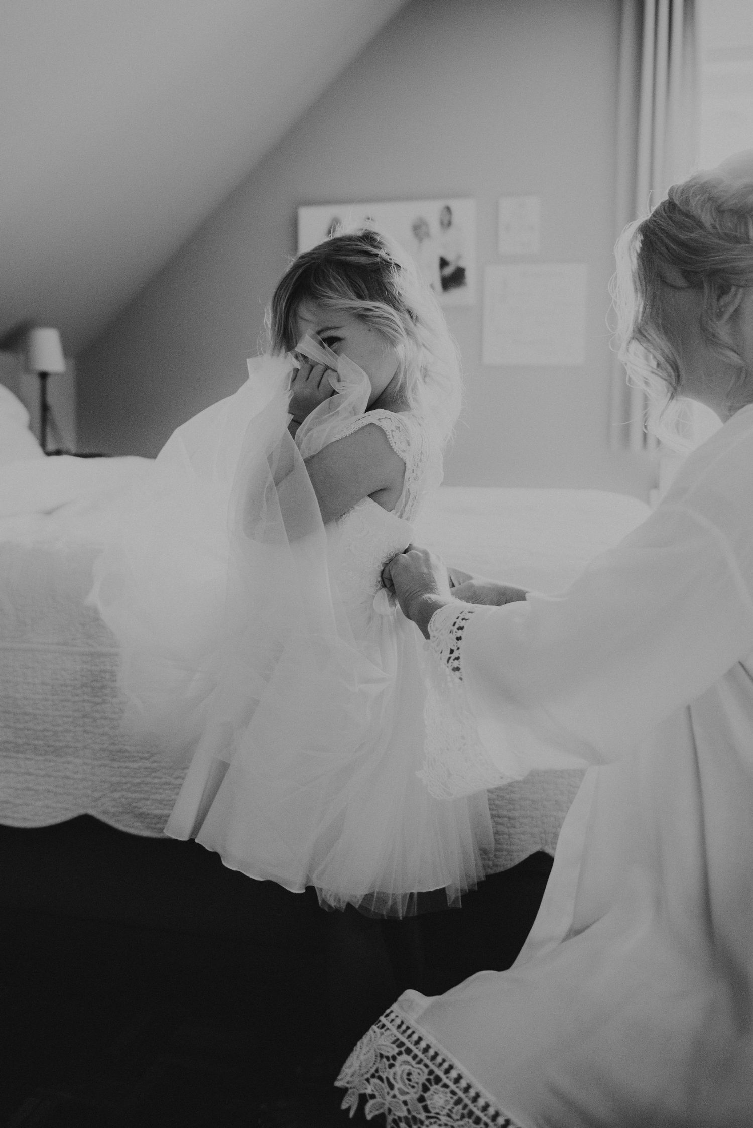 Black and white shots of flowing wedding dress preparations.