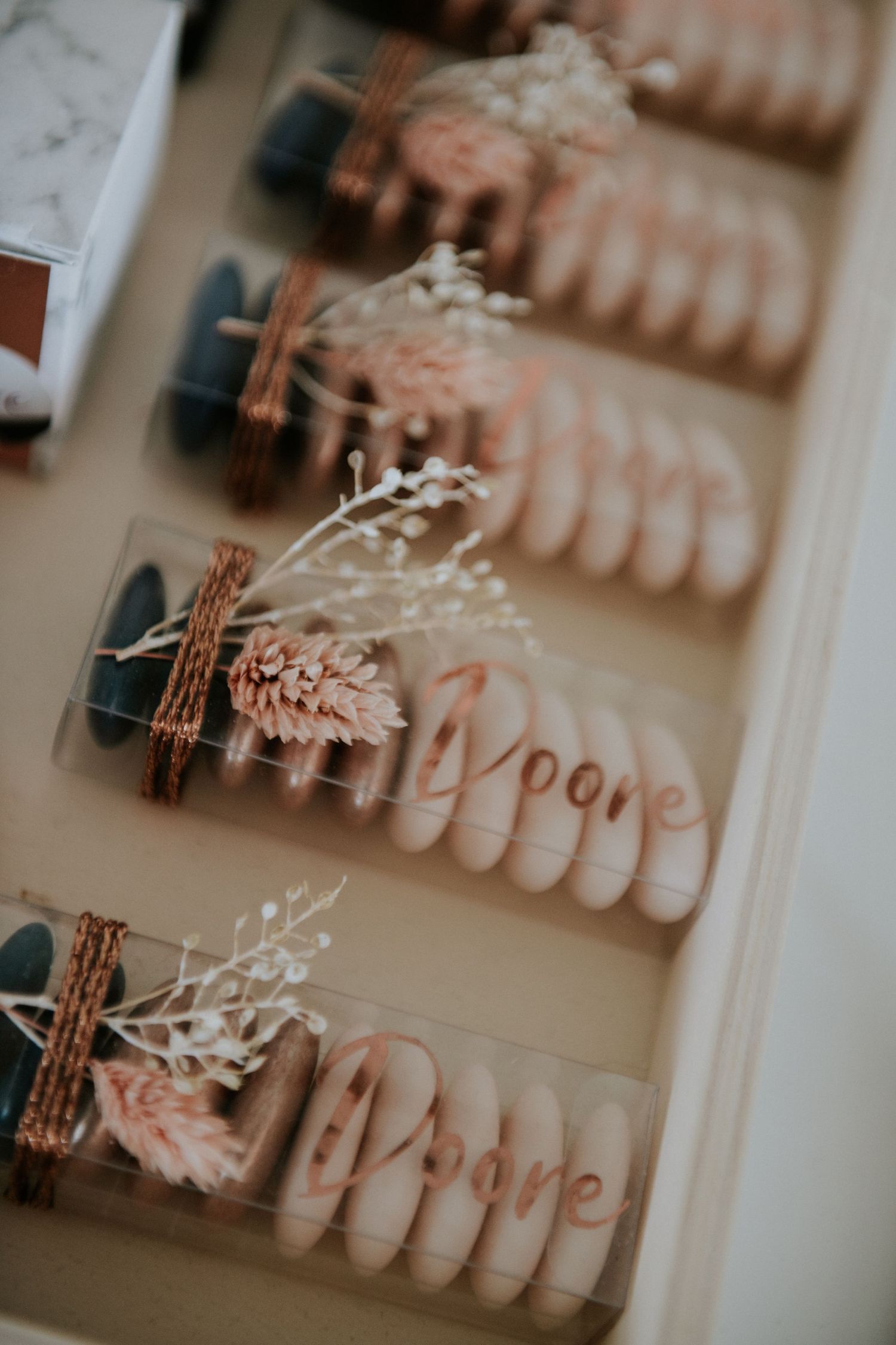 Delicate pink dried flowers and decorative elements arranged in a soft, vintage-inspired display.