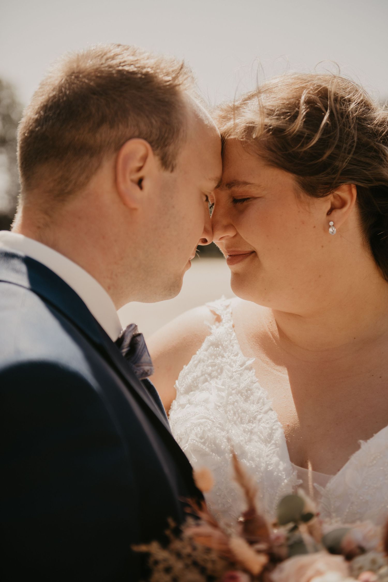 Intimate close-up wedding portrait captured in warm natural lighting.