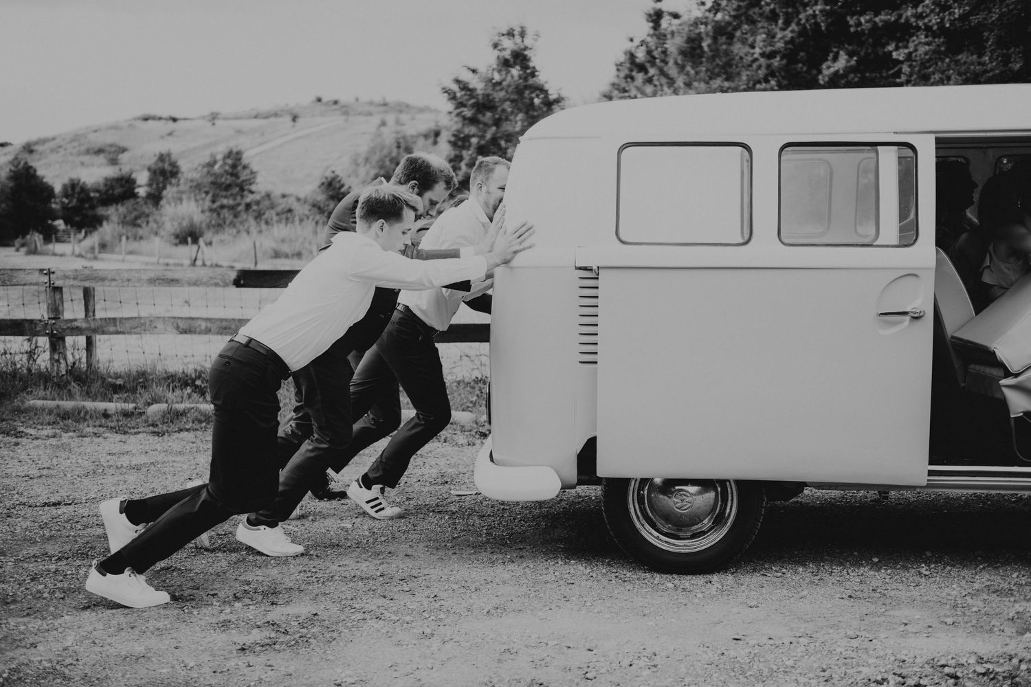 Playful black and white photos with vintage van as wedding prop backdrop.