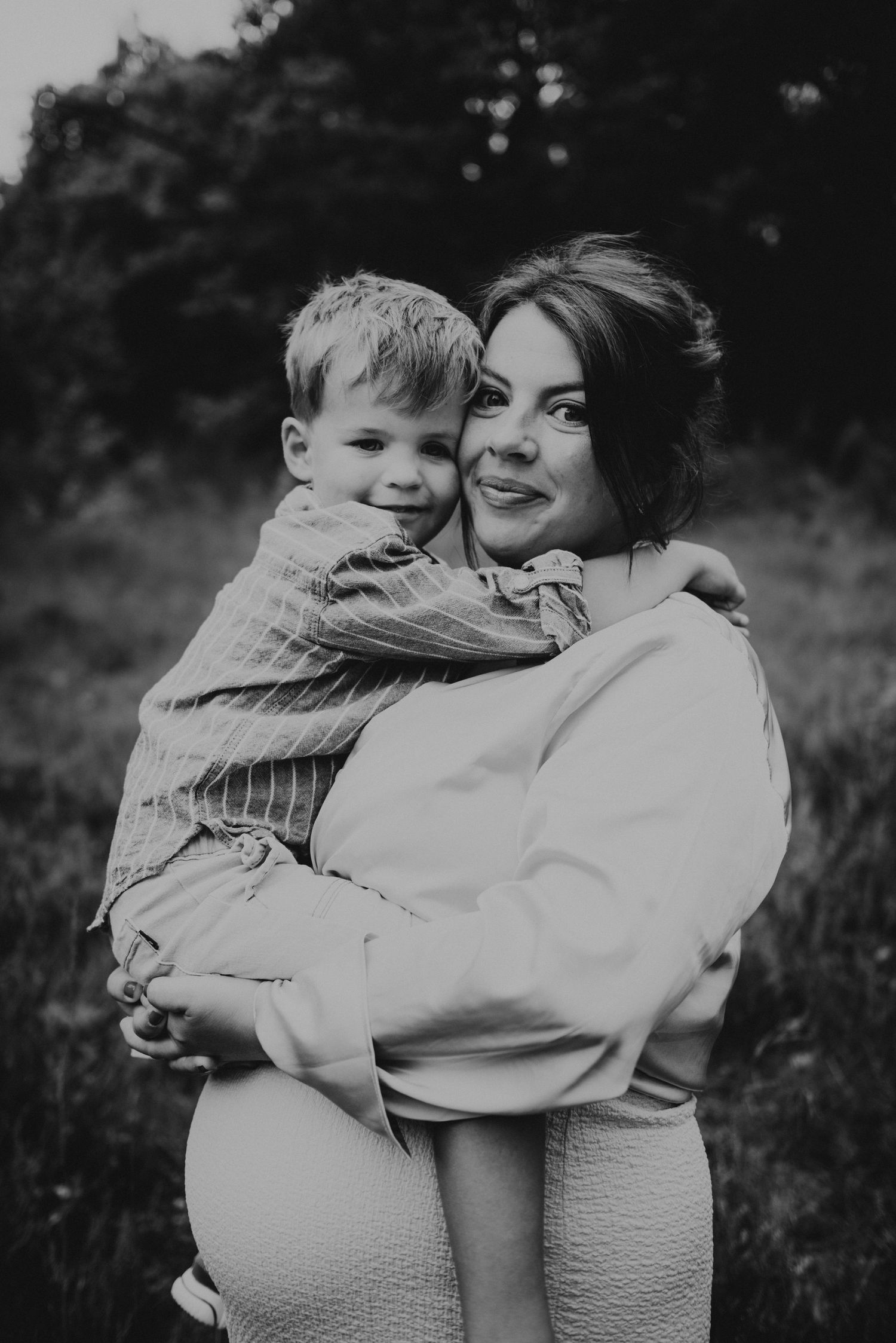 Black and white portrait series showing tender embraces and emotional moments outdoors.