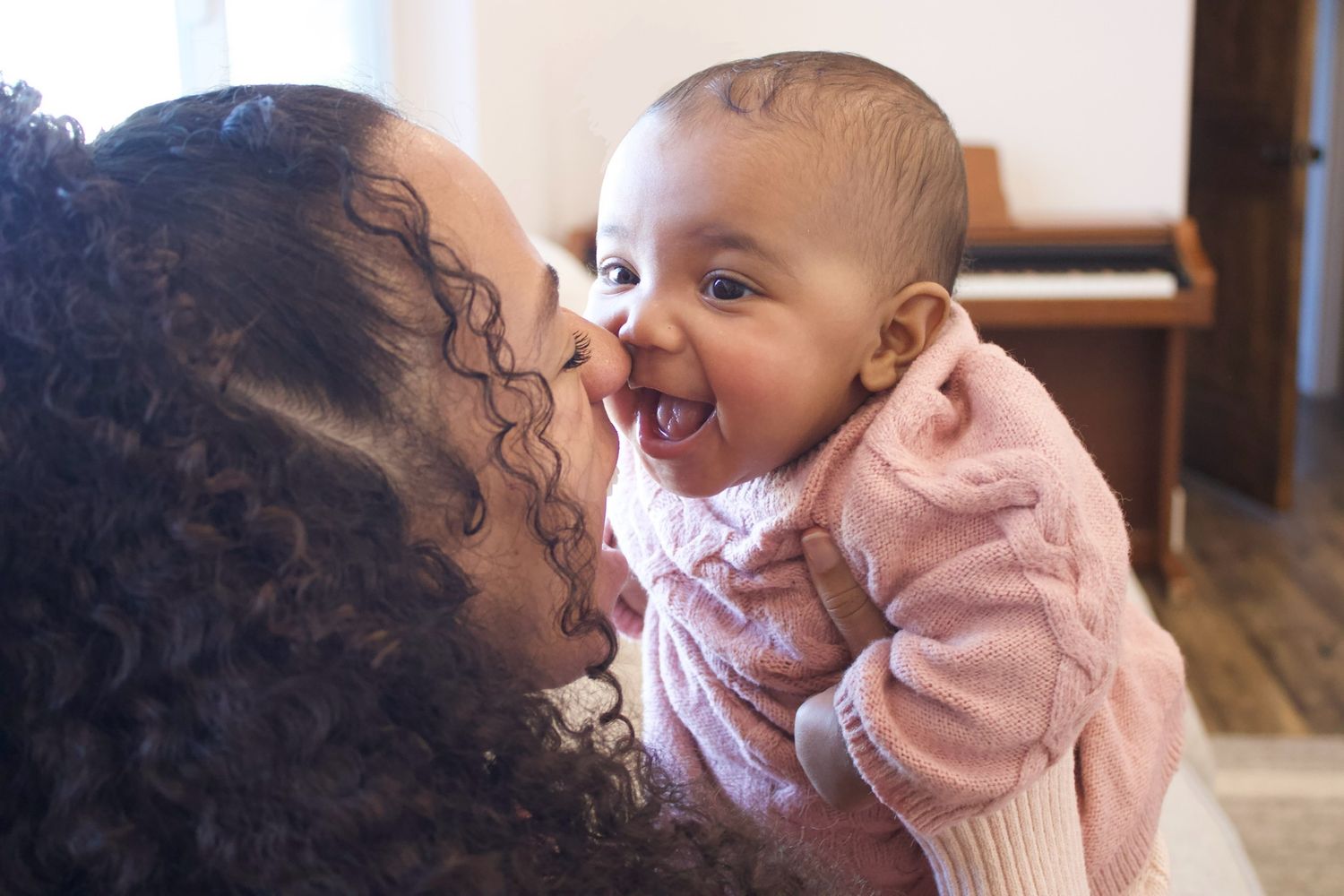 Tender moment shared between mother and baby showing joy and laughter.