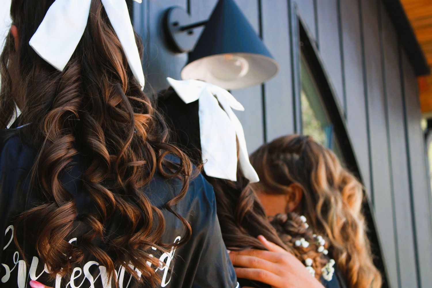 A sequence of close-up shots showing dark wavy hair being styled with white hair clips during a beauty treatment.