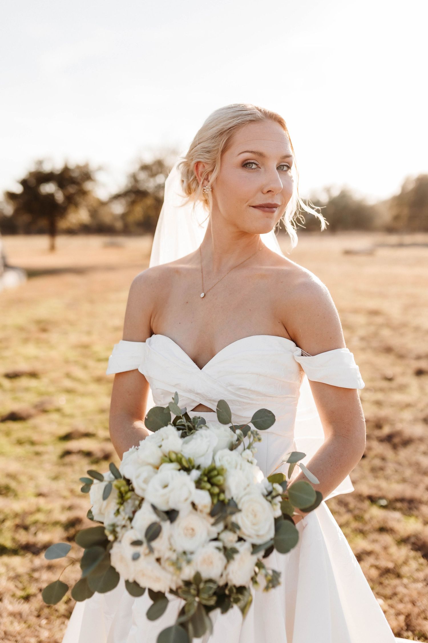 A bridal portrait series showing an off-shoulder wedding dress and white floral bouquet in golden sunlight.