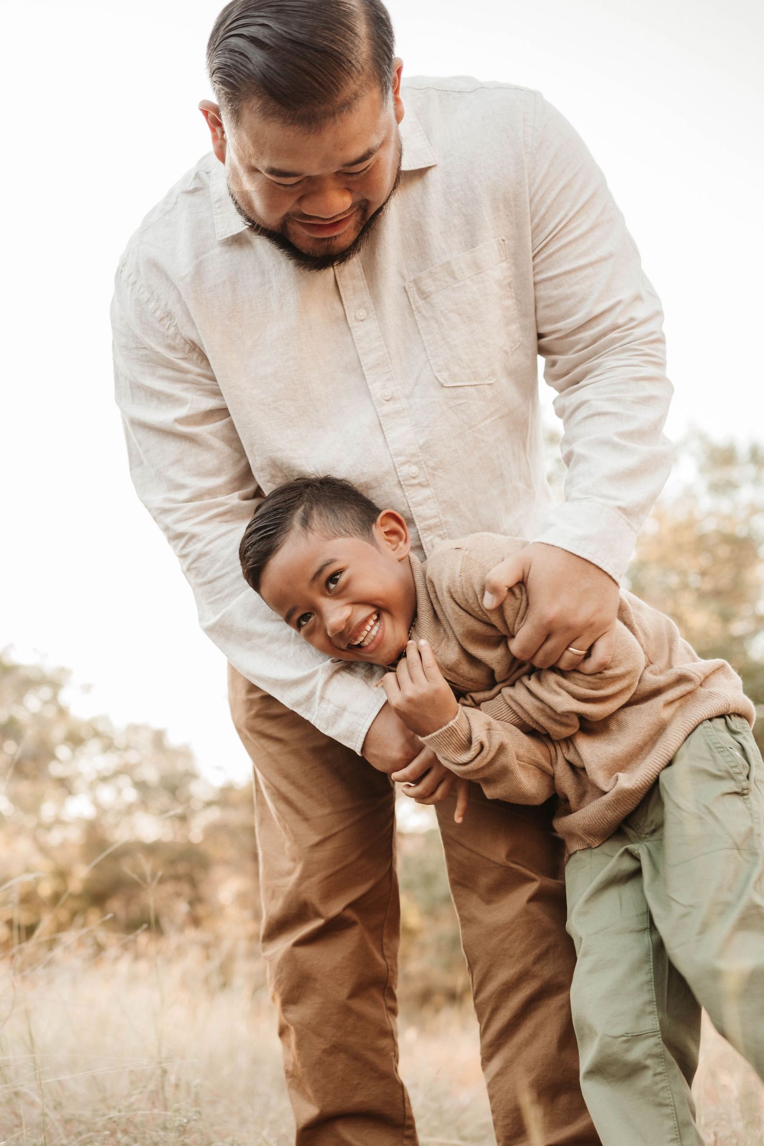 A playful series of photos showing a father and child laughing and embracing in a sun-lit outdoor setting.