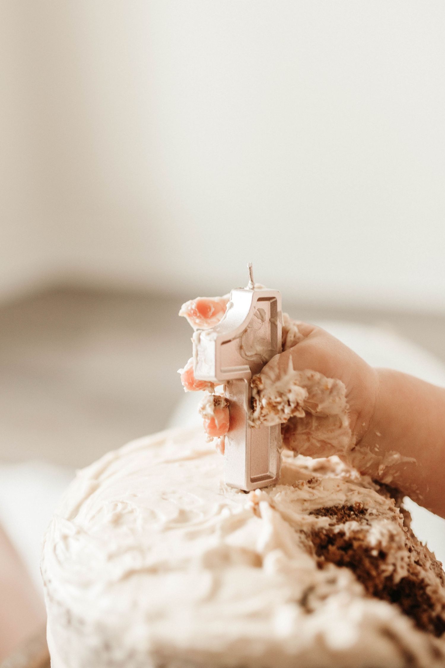 A miniature toy excavator digs into a creamy white frosted dessert surface creating a playful construction scene.