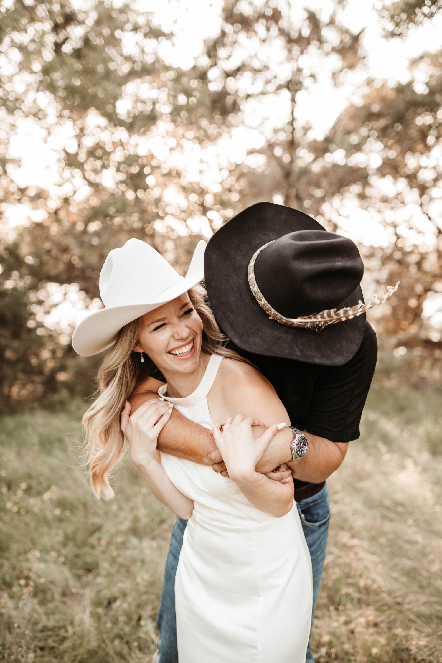 A romantic outdoor couple session shows tender moments between two people in a sun-drenched field at sunset.