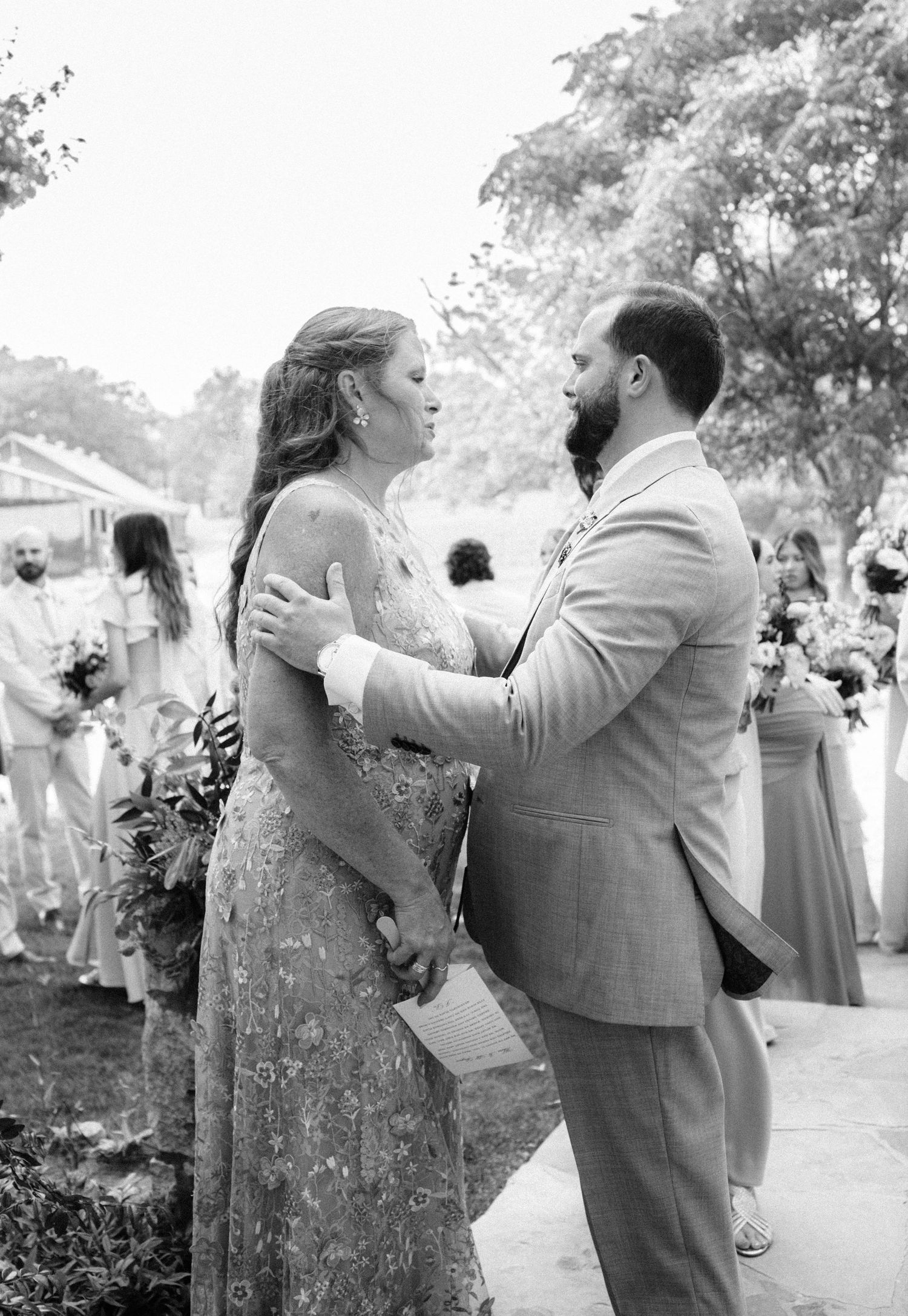 Black and white photo of bride and bearded groom sharing an emotional first look.