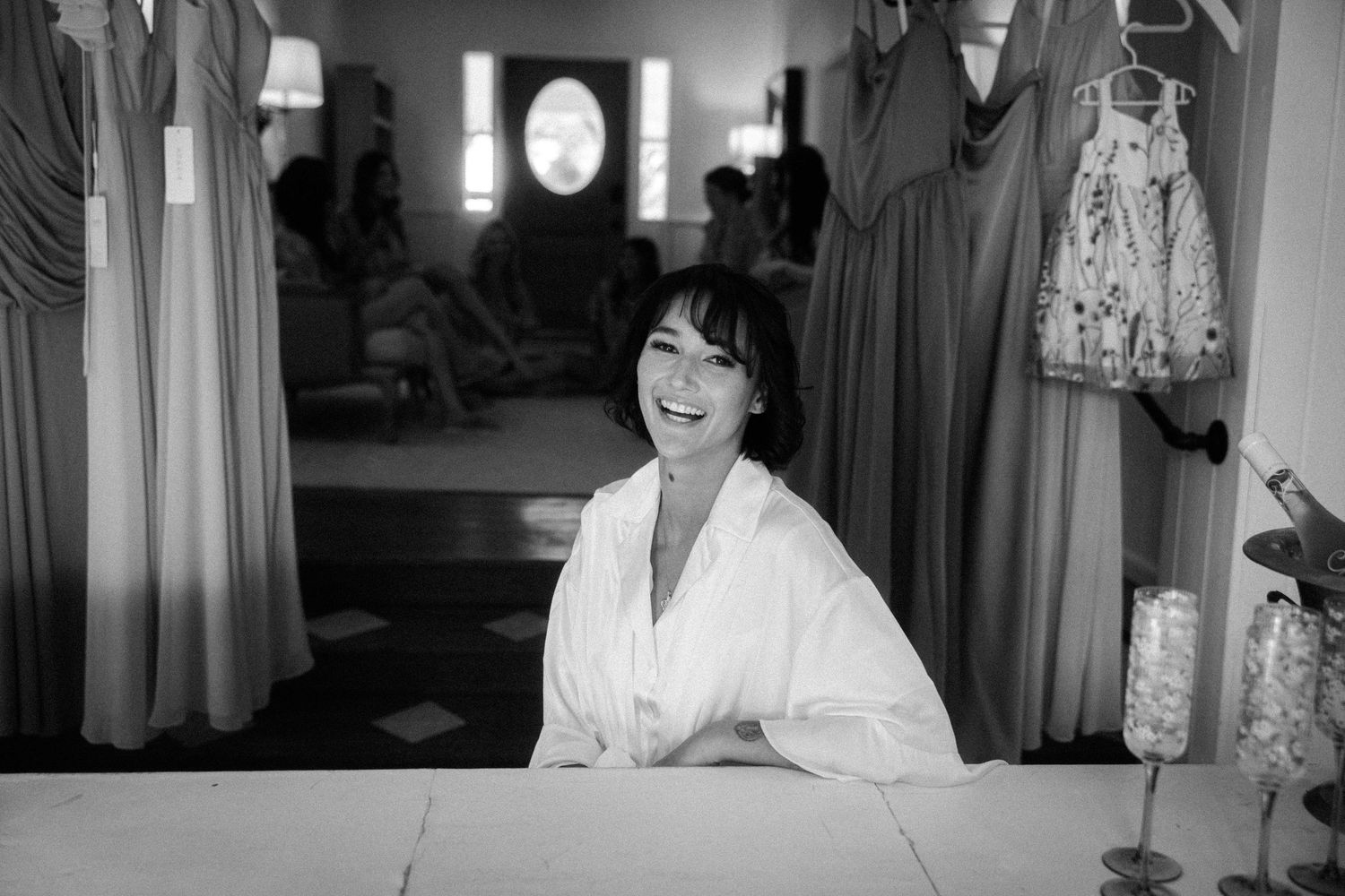 Black and white photo of smiling woman in robe inside a bridal boutique.

Wedding day getting ready photos