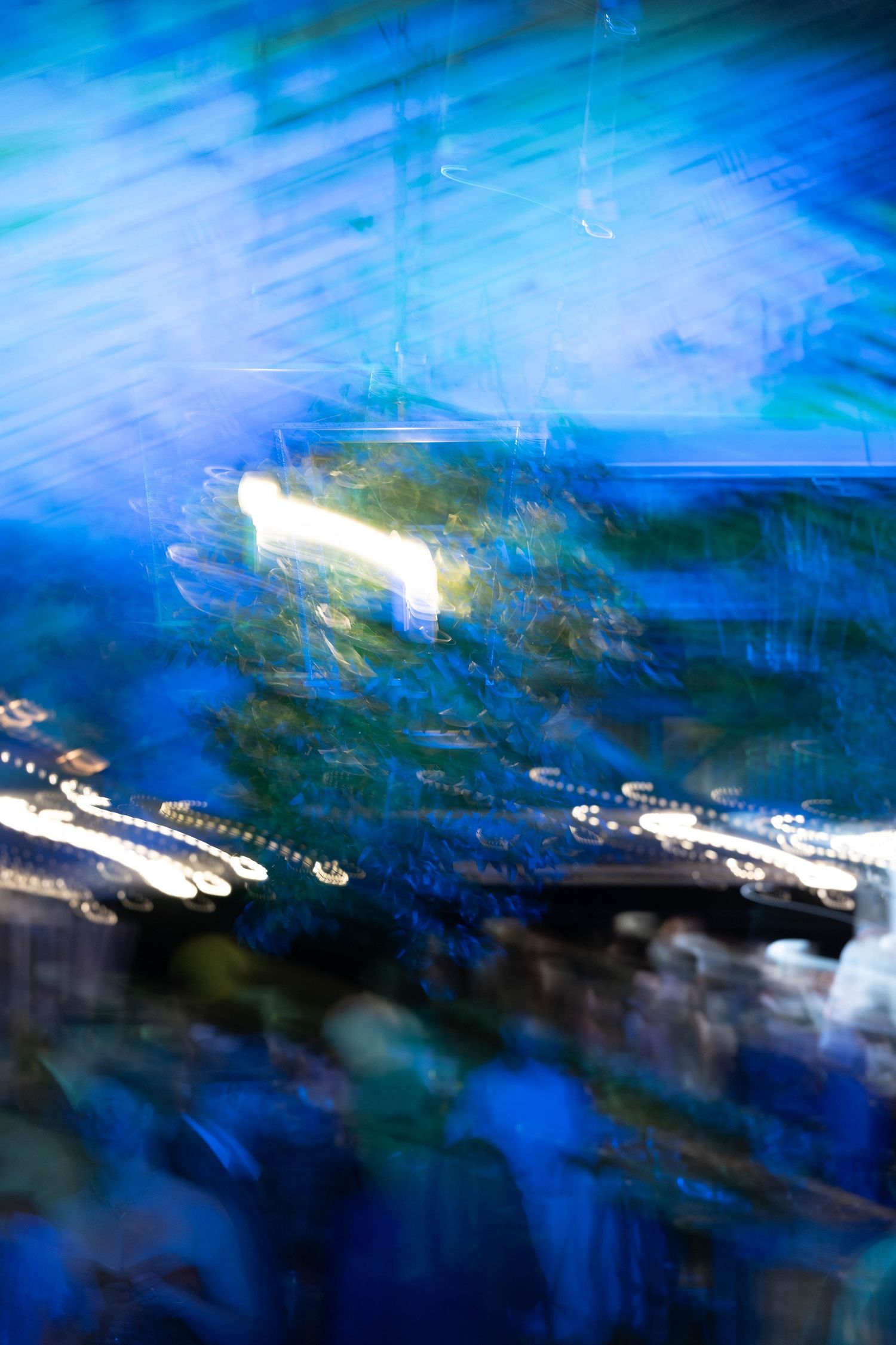 Abstract motion blur photo of wedding reception decor in blue and green tones.
