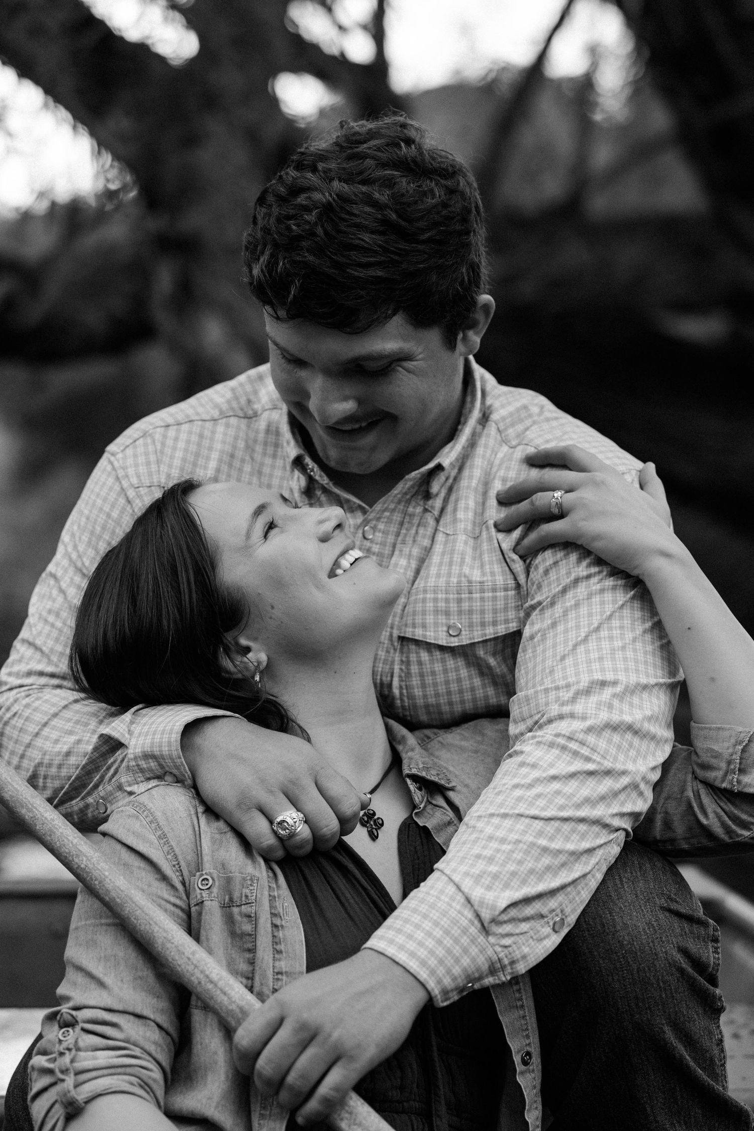 A romantic black and white photo sequence showing a couple embracing and laughing together outdoors.