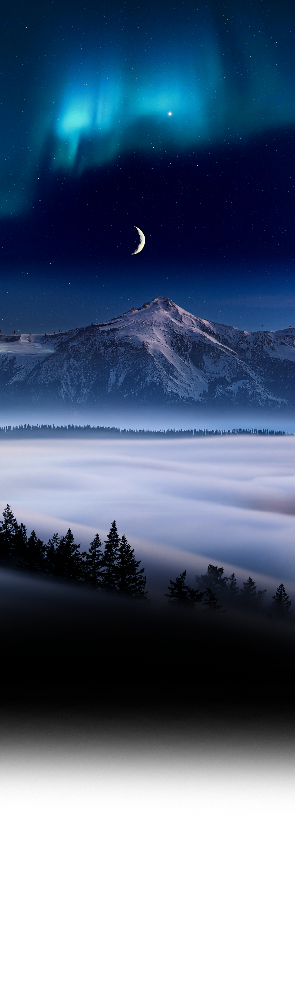 Snowy mountain peak under crescent moon and aurora borealis with fog rolling through evergreen forest.