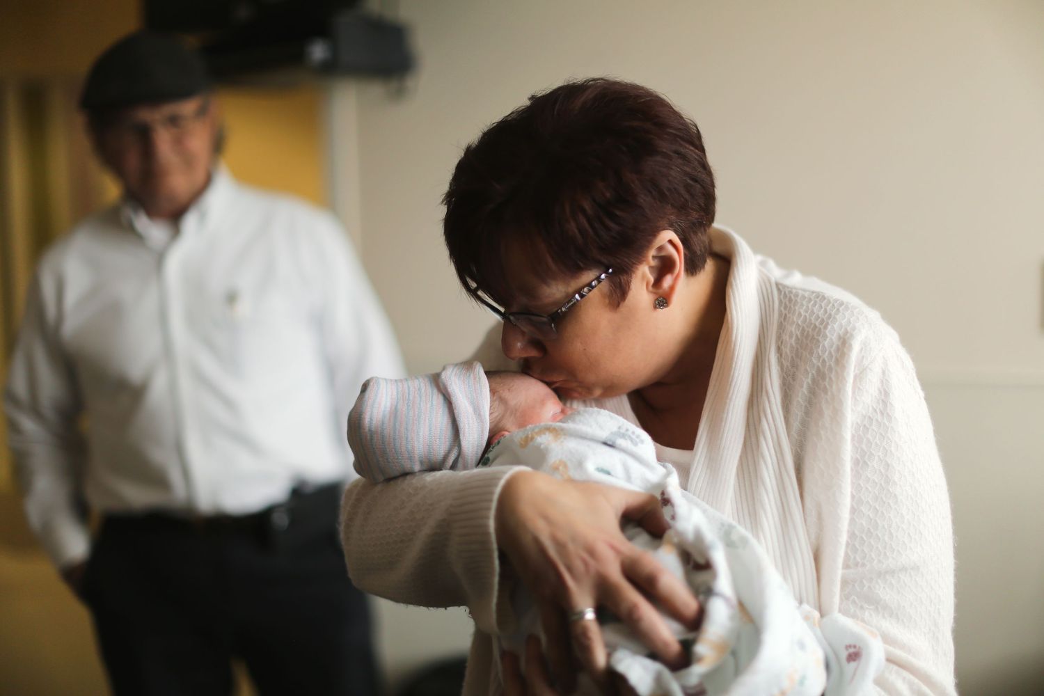 Tender moment with newborn in hospital hallway.