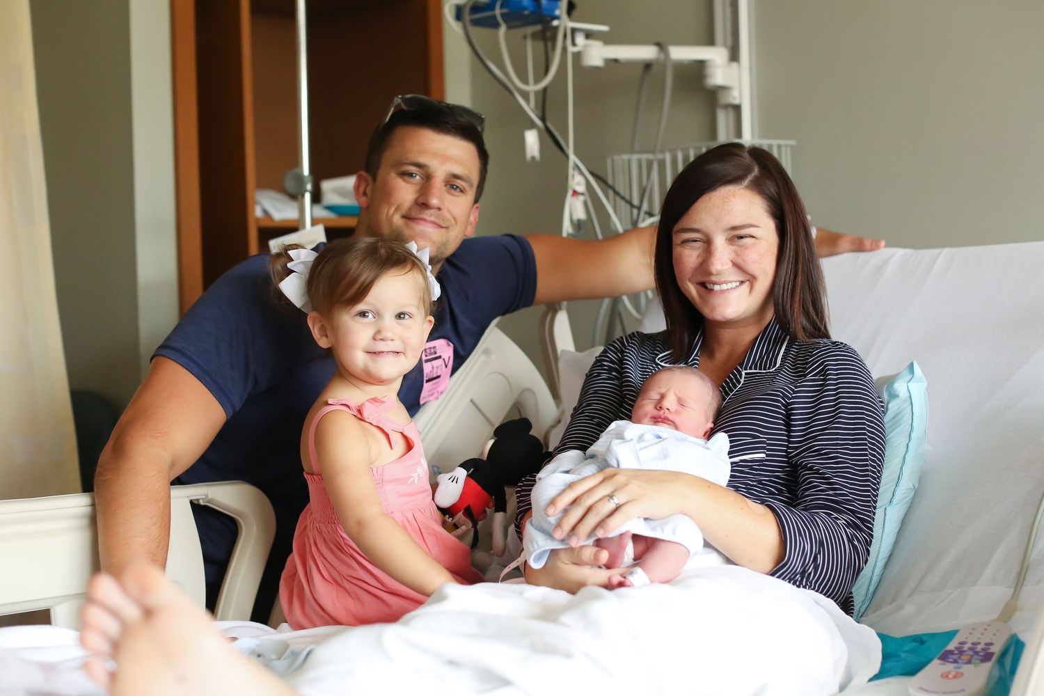Hospital room scene showing tender family moments and visitor interactions around a hospital bed.