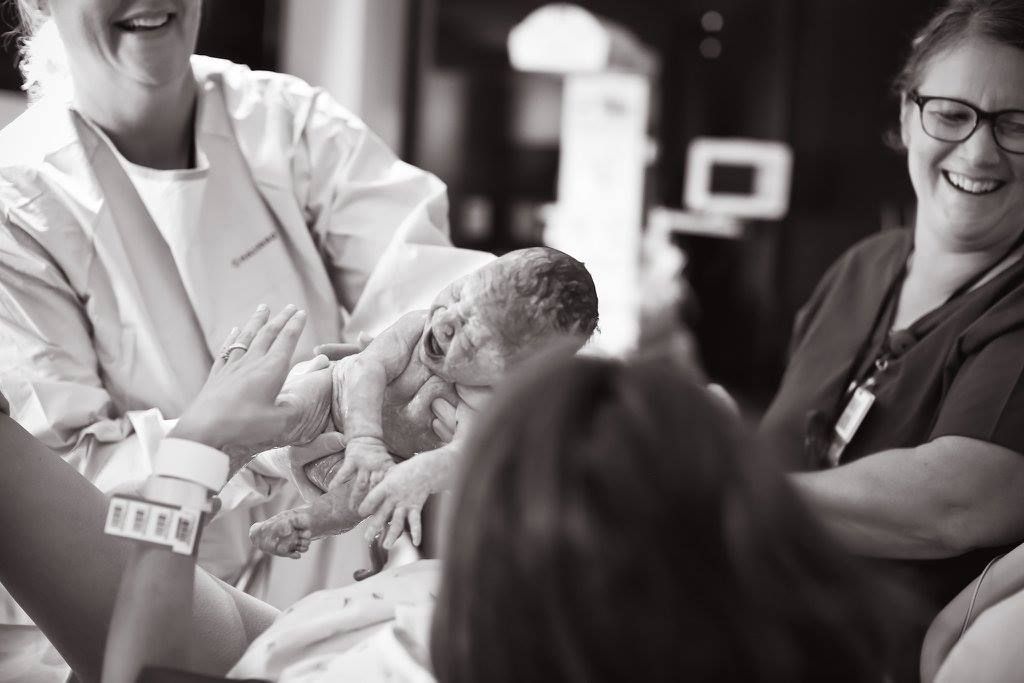 Black and white hospital scene showing medical staff caring for newborn.