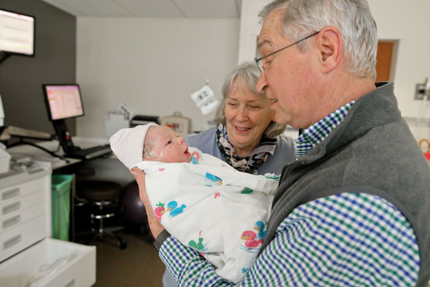 Loving visit with new baby in medical office setting.