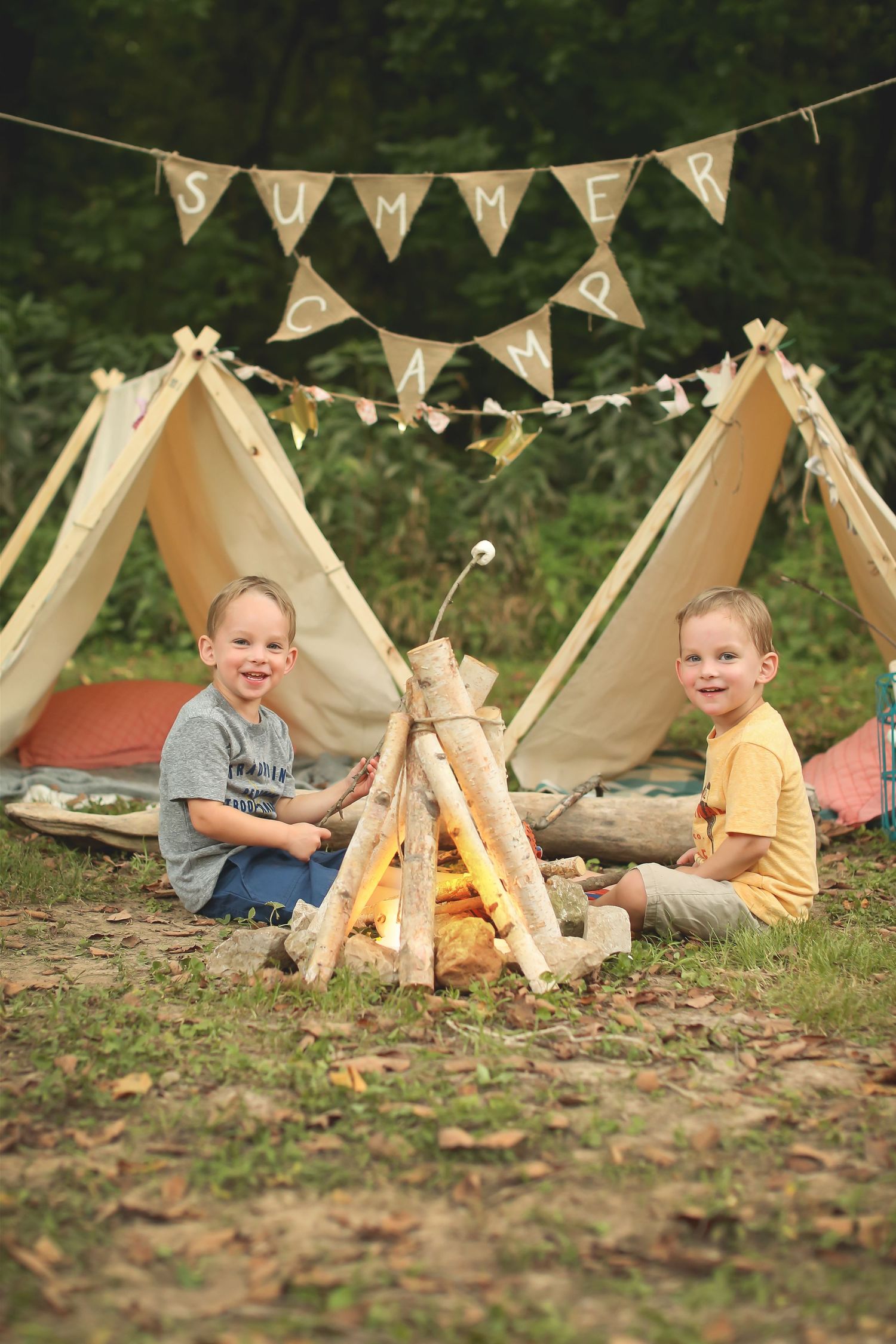 Small teepee tents arranged outdoors with string lights and festive banners.