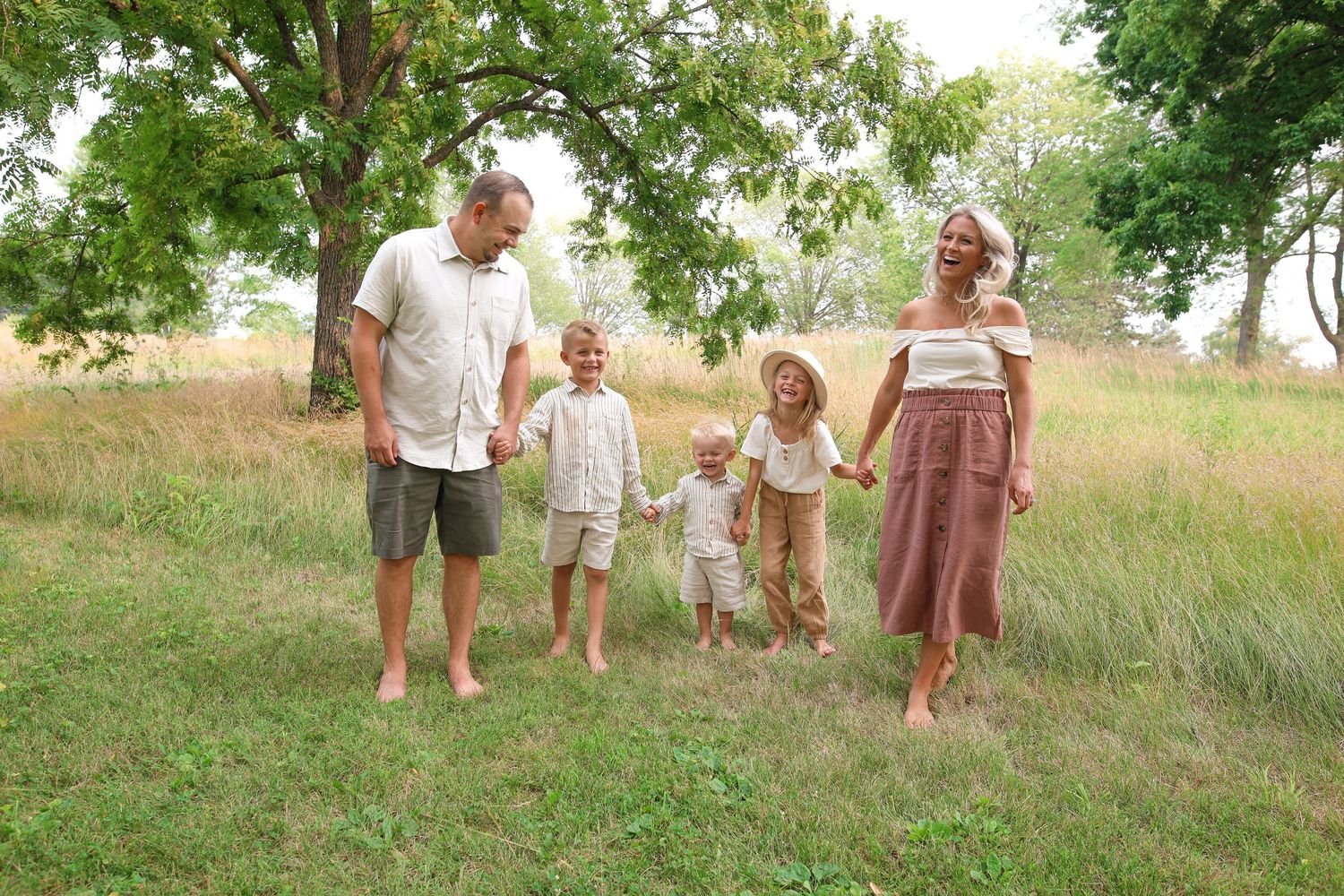 Family walking together through a grassy field on a summer day.